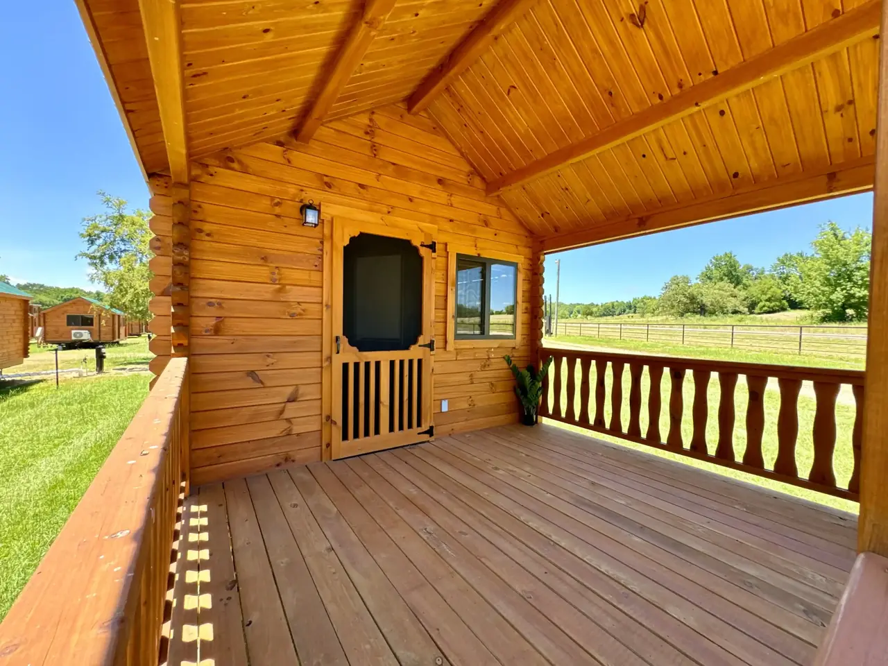 Covered cabin porch with a view of the grounds