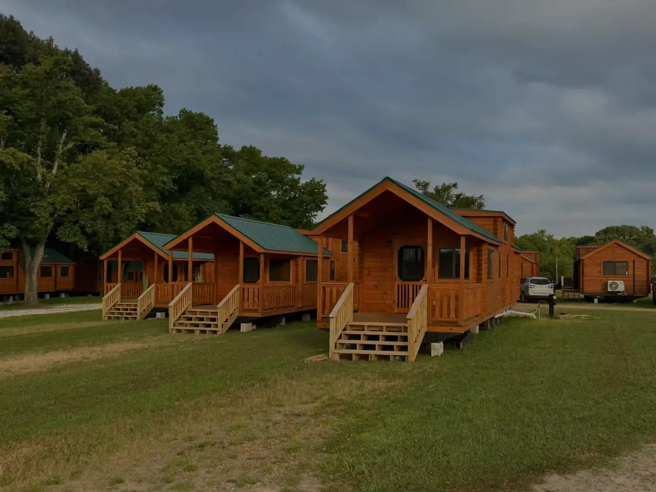 Row of log cabins with covered porches at dusk